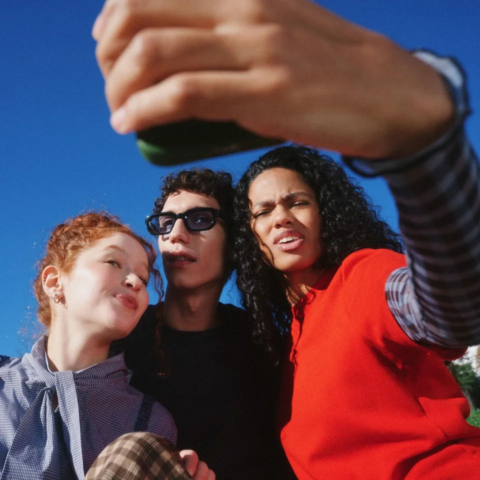 Friends taking a selfie against a blue sky